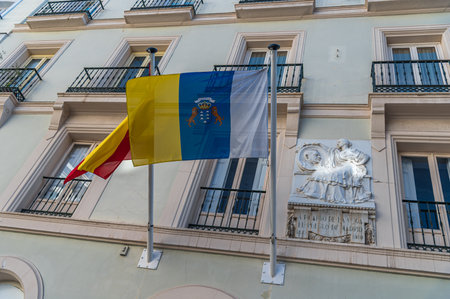 MADRID, SPAIN - NOVEMBER 6, 2022: Canarian flag and a sculptural plaque on a facade in Madrid, as a tribute to Ricardo de la Vega, Spanish playwrightのeditorial素材