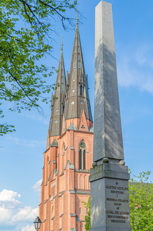 UPPSALA, SWEDEN - JULY 26, 2014: The obelisk designed by Louis Jean Desprez, erected in 1832 in memory of Gustav II Adolf, next to the cathedral of Uppsala, Swedenのeditorial素材