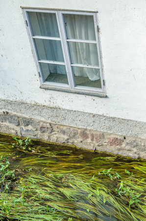Architectural detail, wall and window of a building on the bank of a canalの写真素材