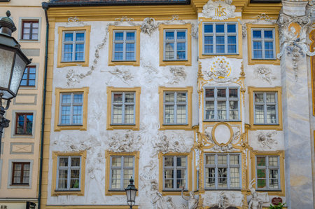 MUNCHEN, GERMANY - JULY 3, 2015: Facade of Asamhaus in Munich, Germany, a 16th-century Baroque residential building acquired by the Asam brothers in 1733, showing white stucco ornamentation on a yellow backgroundのeditorial素材