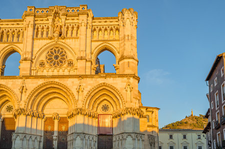 Dusk view of the Gothic Cathedral of Saint Mary and Saint Julian, with facade illuminated by warm light. It is a Catholic cathedral in the town of Cuenca, Castilla La Mancha, Spainの写真素材