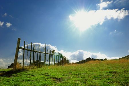 Meadow with fence and blue skyの写真素材