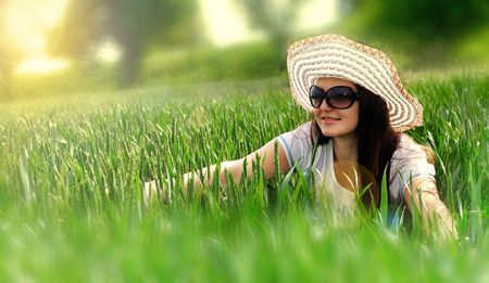 Dreaming girl in a field and shining sunの写真素材