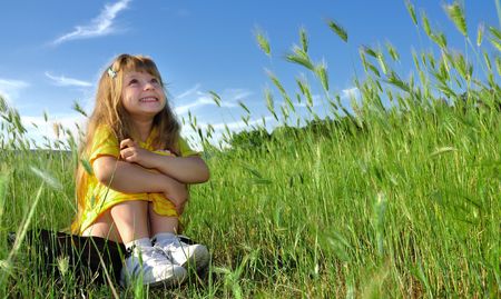 Little girl dreaming  on the grassの写真素材