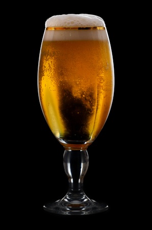 Beer into glass on a black backgroundの写真素材