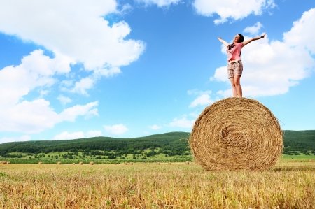 Woman enjoying on the wheat in fieldの写真素材