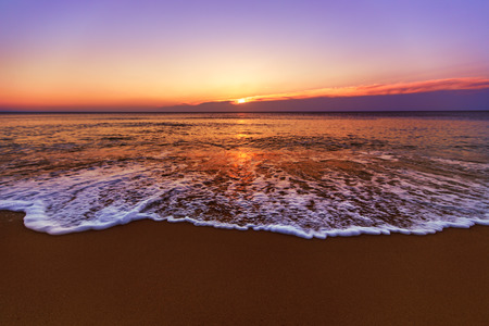 Sunrise light shining on ocean wave with orange tonesの写真素材