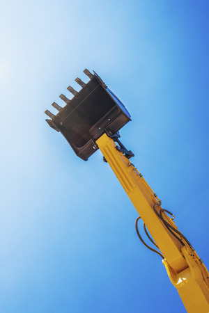 Excavator bucket ready to use isolated on blue skyの写真素材