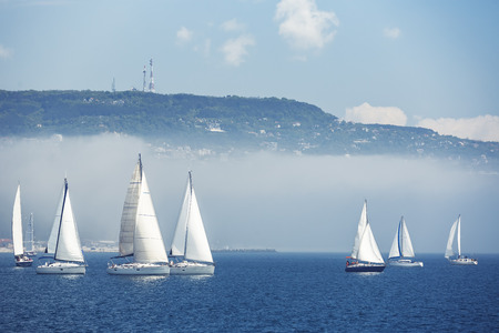 Sailing ship yachts with white sails, deep blue sky