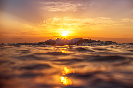 Sunrise and shining waves in ocean の写真素材