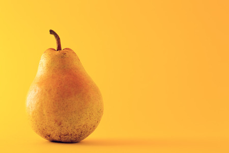 Beautiful ripe yellow pear on yellow background の写真素材