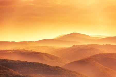 View of a valley in a beautiful early morning with fog between hills