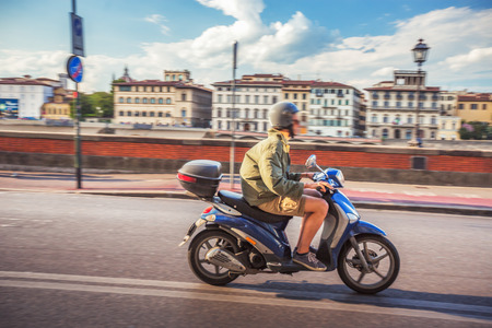 Boy driving scooter in the streets of Florence, Italyの写真素材