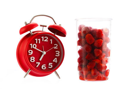 Red vintage alarm clock and raspberry, healthy lifestyle conception