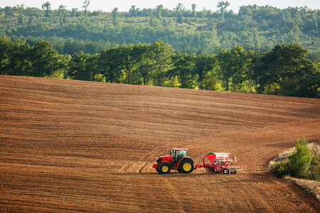 Farmer in tractor preparing farmland with seedbed for the next year