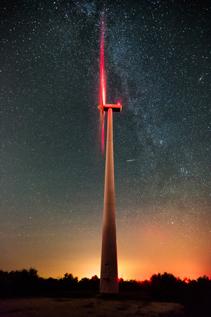 Wind turbines on the starry night sky with milkywayの写真素材