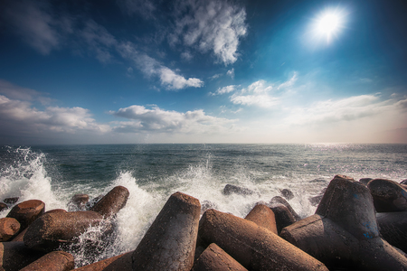 Sea waves breaking on rocks with splashesの写真素材