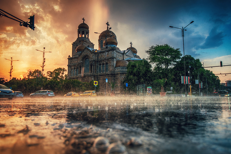 The Cathedral of the Assumption in the city centre of Varna and street traffic. Summer rain.の写真素材