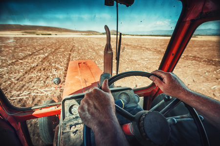 Closeup hands of farmer, sits inside in the tractor cabin.の写真素材
