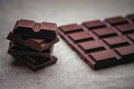 Dark chocolate and background texture of old jute.の写真素材