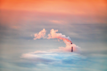 Air pollution by smoke coming out of two factory chimneys. Industrial zone in the city.の写真素材