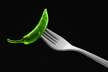 Green chilli isolated on black background.の写真素材