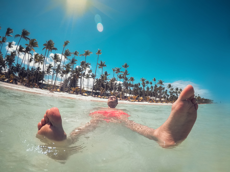 Man enjoying his summer vacation, turquoise water of Caribbean sea and Punta Cana beach.の写真素材
