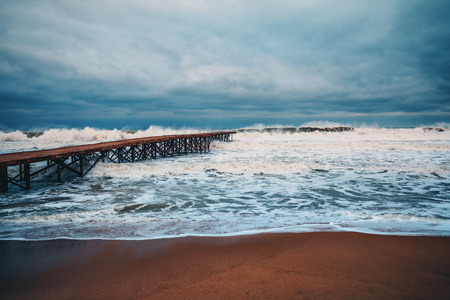 Old broken bridge in the sea and huge waves in the deep sea.の写真素材