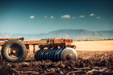 Farmer in tractor preparing land with seedbed cultivatorの写真素材