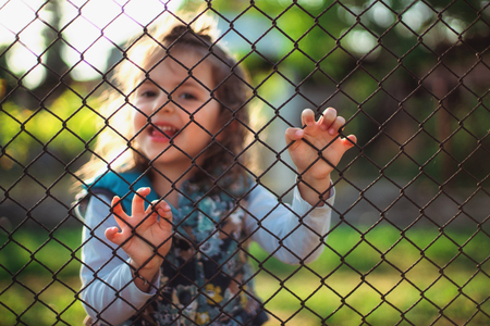 Little girl behind a fence.の写真素材