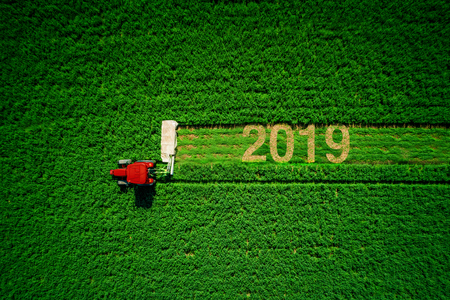 Tractor mowing green field, aerial view.の写真素材