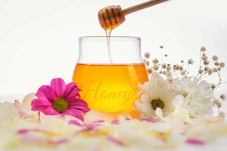 Honey and flowers on a wooden background.の写真素材