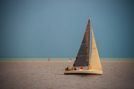 Sailing Regatta in the wind through the waves at the sea.