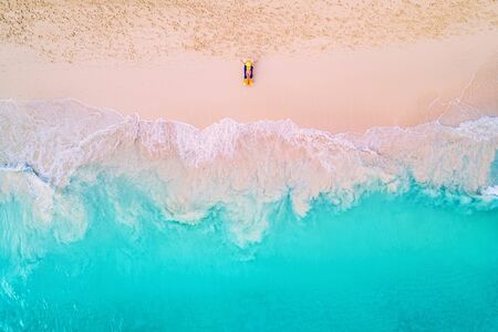 Aerial view of a woman on the beach in a bikini lying and sunbathing.の写真素材