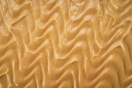 Texture of cake with peanuts, walnuts, chocolate and caramel cream as background