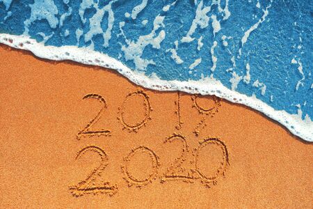 Happy New Year 2020 concept, lettering on the beach. Sea sunrise.