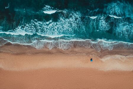Aerial top view from drone of sandy beach with turquoise sea waves with copy space for text.の写真素材