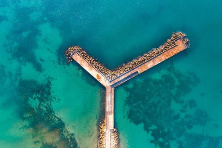 Aerial view of sea, coast and wave breaker stonesの写真素材