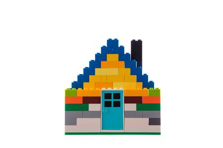 House made of classic building blocks and bricks, white studio background.