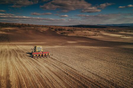 Farmer in tractor preparing farmland with seedbed for the next yearの写真素材
