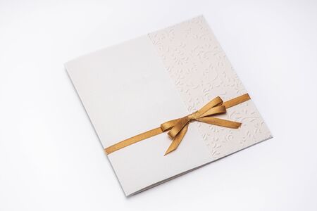Greeting card with gold ribbon isolated on white background.の写真素材