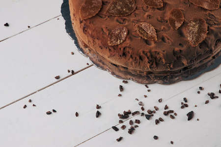 Chocolate homemade cake with nuts and apricot jelly on wooden background