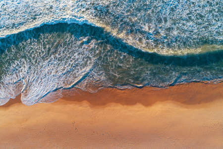Aerial top view from drone of sandy beach with turquoise sea waves with copy space for text.の写真素材