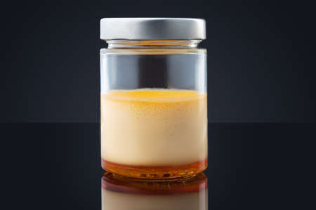 Cream caramel in a jar isolated on black backgroundの写真素材