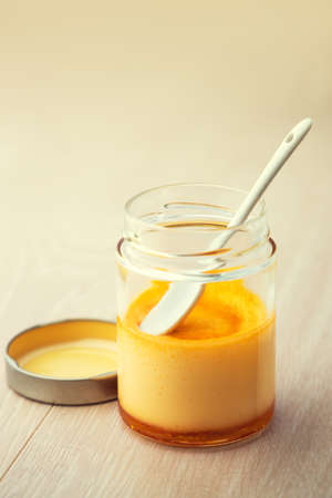 Cream caramel in a jar isolated on wooden backgroundの写真素材
