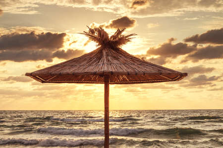 Straw umbrella on tropical sea beachの写真素材