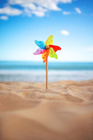 Pinwheel on a beach sand against blue sky and sea, summer holidayの写真素材
