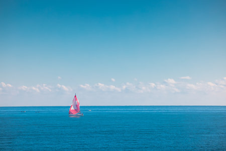 Sea and sailing wind boat. Sailboat over blue waves and sunny skyの写真素材