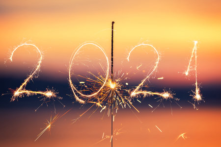 2021 written with Sparkle firework on sunset background, happy new year 2021 concept.の写真素材