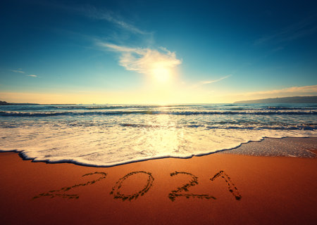 Beautiful cloudscape over the sea, sunrise shot. Happy New Year 2020 written on seashore.の写真素材